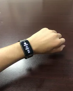 Primer plano de una pulsera de actividad inteligente en la muñeca con menú de configuración.