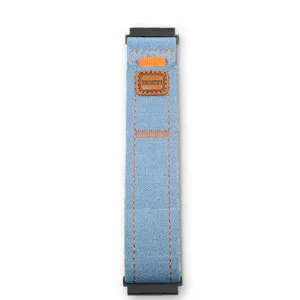 Vista dettagliata del cinturino per orologio in tela di jeans con cuciture ed etichetta.