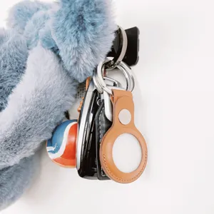 Detailed view of the leather protective case and plush keychain accessory, showing fine texture.