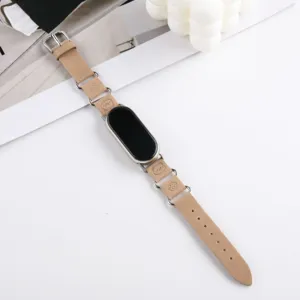 Gros plan sur le bracelet de montre en cuir kaki avec anneaux métalliques et charmant motif d'ours.