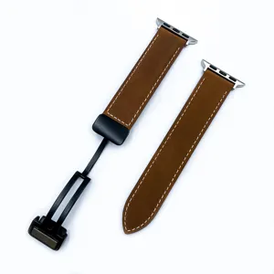 Dettaglio in primo piano del cinturino in pelle marrone con fibbia pieghevole magnetica.