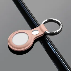 Detail shot of pink leather AirTag protective case with metal keyring for tracking device.
