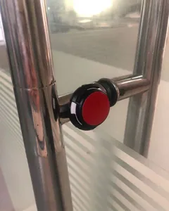 Detailed view of magnetic protective case for Apple AirTag installed on metal door handle.
