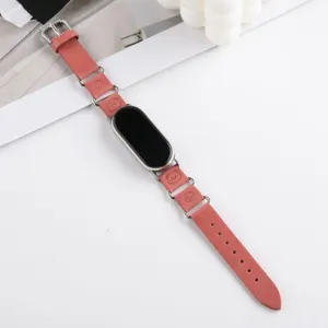 Bracelet de montre connectée en cuir rose avec anneaux métalliques et jolis motifs.