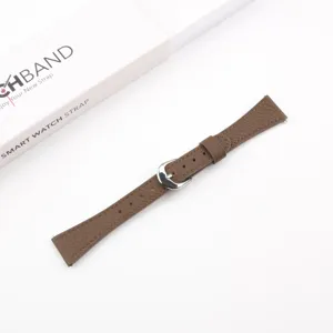 Brown leather watch strap detail, litchi grain texture, elegant metal pin buckle.