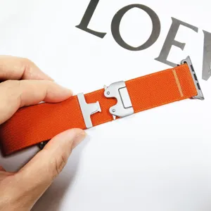 Dettaglio del cinturino per orologio in nylon arancione con fibbia metallica tattica sicura.