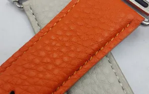 Vue en gros plan détaillée du bracelet de montre en cuir texturé de rechange pour Apple Watch.