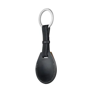 Detail view of the black leather AirTag protective case and key ring, featuring white stitching.