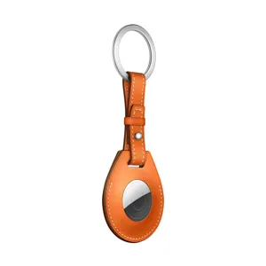 Orange leather AirTag case keychain detail showing microfiber texture and metal ring clasp.