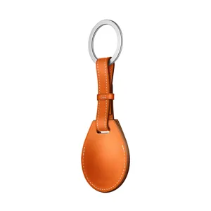 Detailed close-up of orange leather AirTag key ring featuring white contrast stitching.