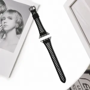 Vue de détail du bracelet de montre en cuir noir et blanc avec une texture tissée.
