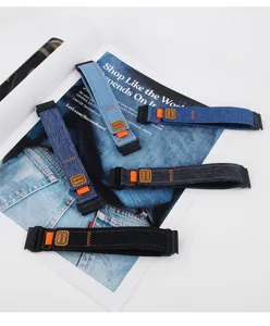 Vue détaillée du bracelet de montre en toile denim à dégagement rapide avec accent orange.