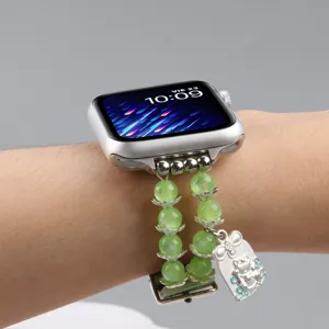 Gros plan détaillé du bracelet de rechange en perles vertes pour Apple Watch avec un charm.