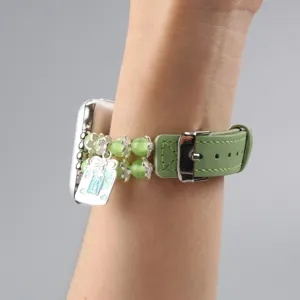 Vue détaillée du bracelet de montre en cuir vert et perles œil de chat avec pendentif.