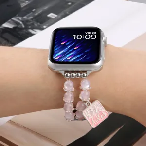 Vue détaillée du bracelet de montre en perles avec pendentif rose pour Apple Watch.