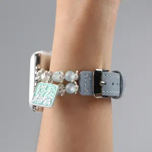 Détail de bracelet montre en cuir perlé œil-de-chat avec breloque pour montre connectée.