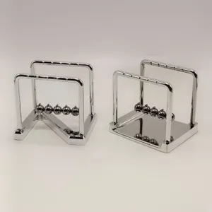 Close-up detail of metal balance balls with Z-shaped and square chrome bases for desk decor.