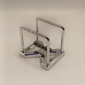 Close up detail of a silver metal kinetic energy ball Newton cradle desk toy ornament.