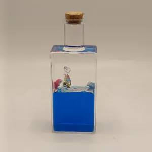 Creative liquid drift bottle ornament with blue water miniature sailboat inside home decor desk.