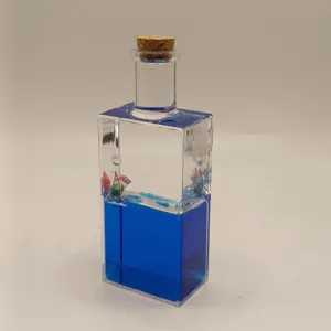 Creative liquid drift bottle with blue ocean fluid and mini sailboat for desk decor.