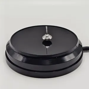 Metal spinning top desk toy ornament with black USB electronic rotating base detail shot.