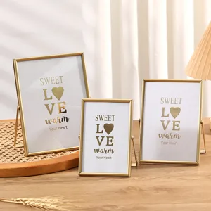 Gold metal photo frame detail display with modern minimalist design and clear glass front.