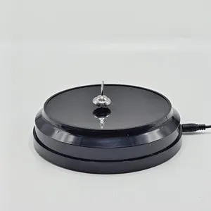 Close up detail shot of a magnetic levitation spinning top on a sleek black electronic base.