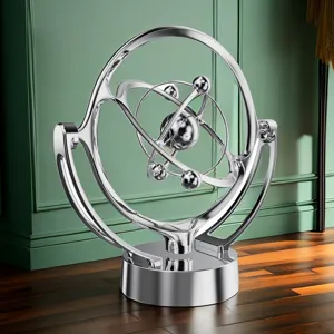 Primo piano macchina moto perpetuo orbita celeste argentata, giocattolo decorativo ufficio moderno.