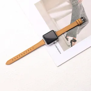 Vue détaillée d'un bracelet de montre fin en cuir marron avec coutures et boucle métal.