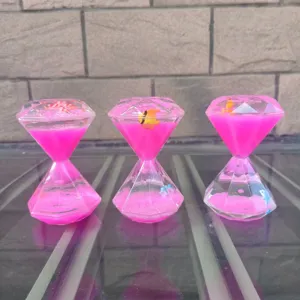 Details van het creatieve diamanten vloeibare bewegingsornament met zwemmende vissen op bureau.