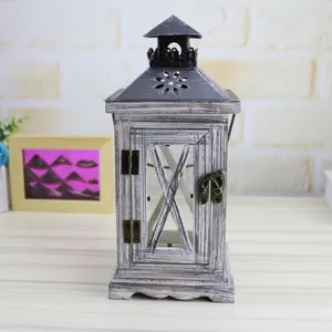 Wooden candle lantern detail showing vintage distressed wood frame and antique metal roof top.