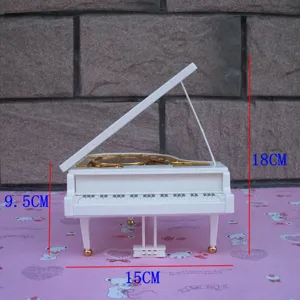 Miniature white grand piano music box detail view, rotating musical instrument decor piece.