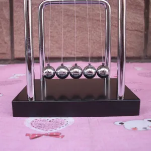 Close-up detail of the metal balance balls Newton cradle desk toy showing physics motion.