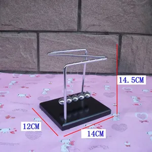 Detail view of the Z-shaped Newton cradle balance balls with wooden base and metal frame.