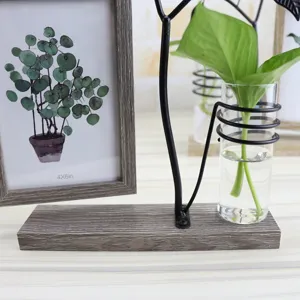 Detail view of the wooden photo frame with metal stand and hydroponic glass vase for plants.