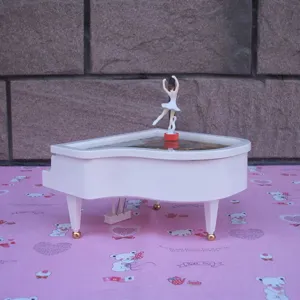 White piano music box with rotating ballerina figurine, cute gift and cake decoration for birthday.
