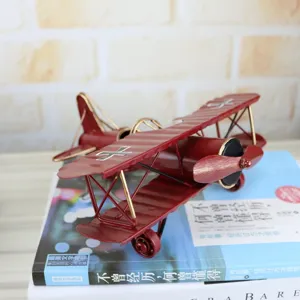 Vintage metal airplane model detail view, retro red biplane ornament for home decor display.