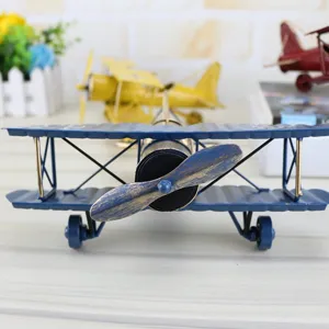 Close-up of vintage handmade iron biplane model, retro metal airplane decor for desk display.