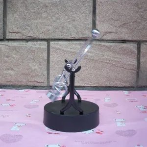Kinetic art desk toy detail showing metal swinging arms and black stable base for office.