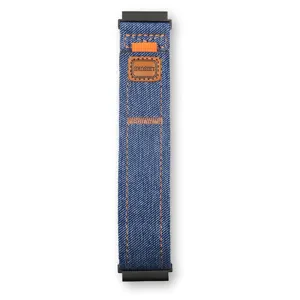 Vista dettagliata di un cinturino per smartwatch in tela denim blu con toppa in pelle.