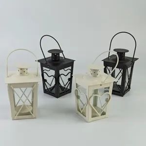 Detailed view of metal candle lanterns featuring heart design and handle for home decor.