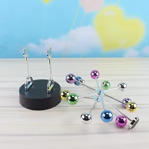 Detailed view of the magnetic perpetual motion desk toy with colorful metallic swinging balls.