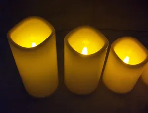 Nahaufnahme zylindrischer LED-Elektronikkerzen mit warmgelbem, leuchtendem Flammeneffekt.