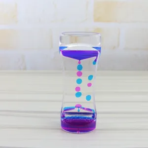 Vista dettagliata della clessidra a olio liquido con gocce blu e viola per il relax e decoro.