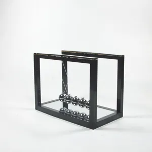Detailed view of the Newton's cradle pendulum balls with reflective mirrored glass base.