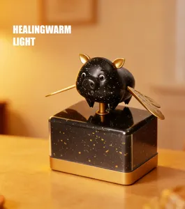 Dettaglio luce ambiente maialino volante, design nero dorato con ali dorate eleganti e uniche.
