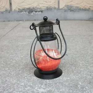 Detailed view of miniature metal lantern gel candle holder with red wax inside, perfect decor.