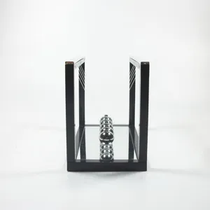 Newton's cradle balance balls toy with reflective mirror base and black frame for office decor.