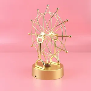 Detailed close-up view of the golden metallic Ferris wheel kinetic motion desk ornament.