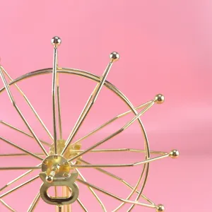 Golden metal Ferris wheel kinetic desk toy detail, creative office and home decor ornament.